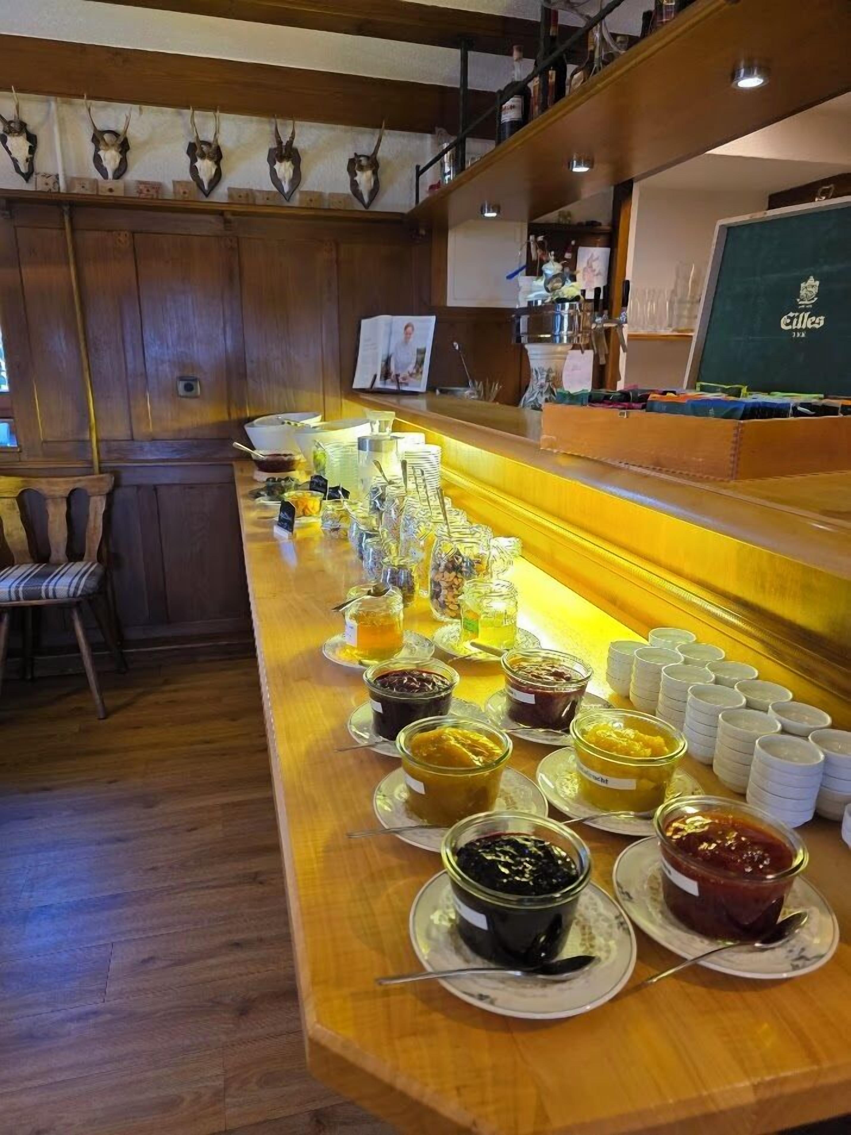 A buffet bar with various food items and condiments.