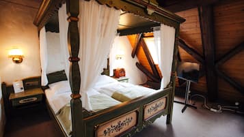 Una cama con dosel, una mesita de noche y una lámpara.