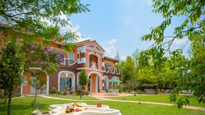 A large, two-story house with a well-maintained garden, including a play area with toys and a paved walkway. - Saint Paul Villa (Yuchi)