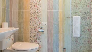 Un baño con inodoro, lavamanos y zona de ducha.