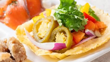 Un plato con tortilla, verduras y un trozo de pollo frito.
