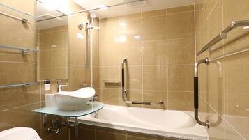 A modern bathroom with a glass-enclosed sink, a bathtub, and a shower area.