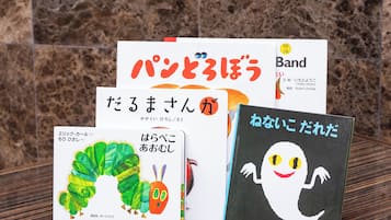 A collection of books with Japanese text on a wooden surface.