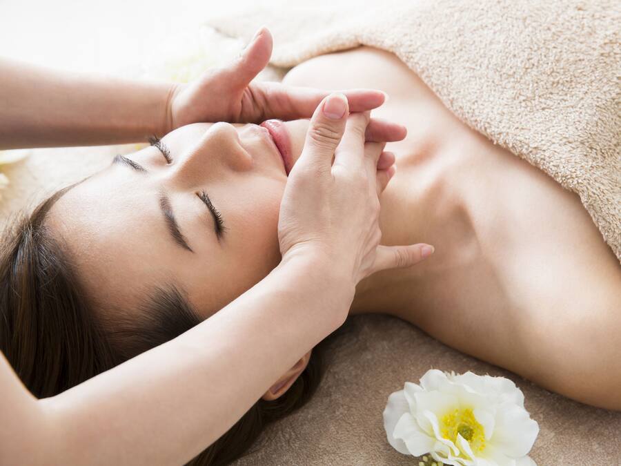 A person receiving a massage with a towel and a flower on the side.
