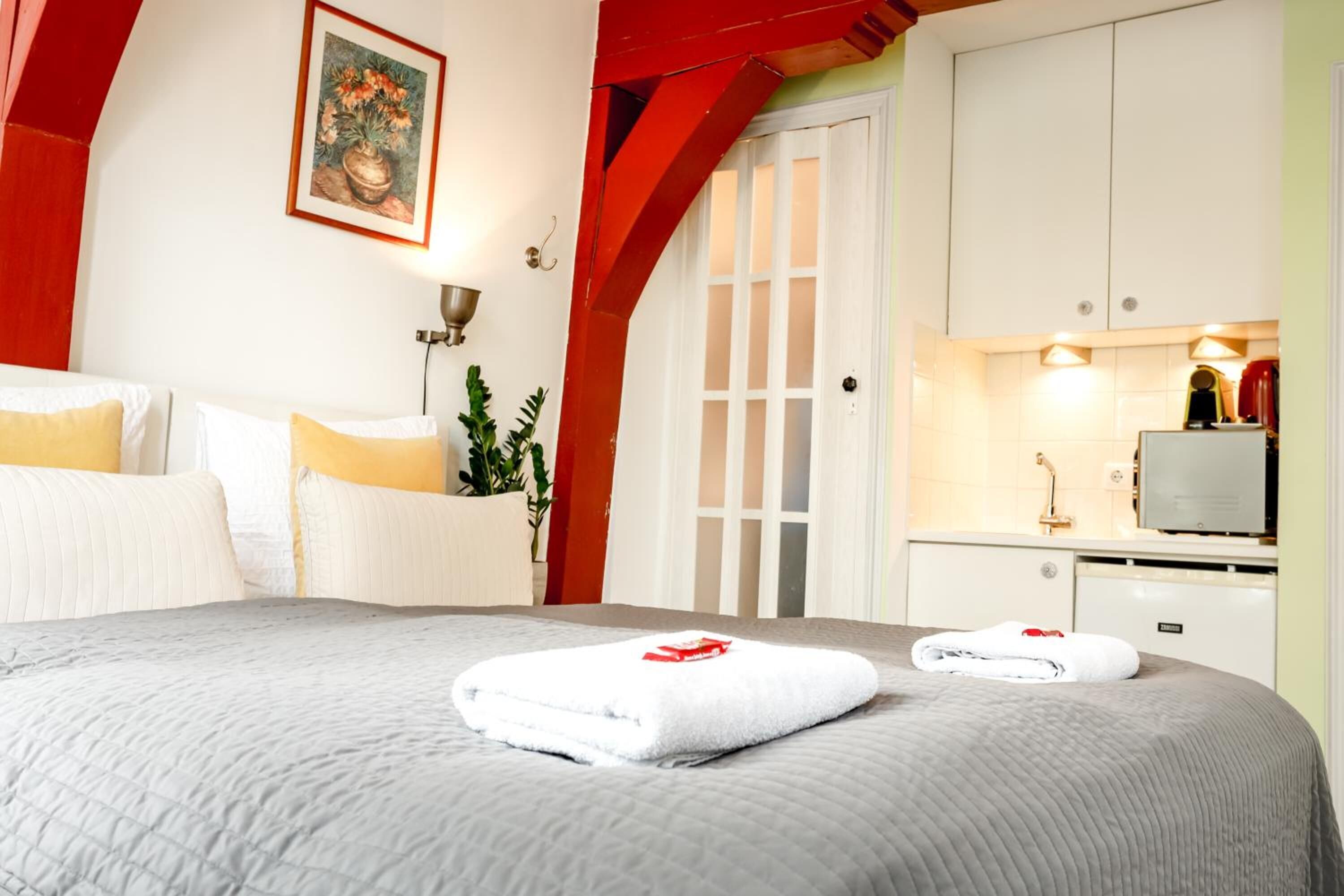 Een hotelkamer met een bed, een bureau en een kitchenette.
