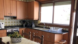 Una cocina con armarios de madera, una estufa, un lavamanos y un ventanal.
