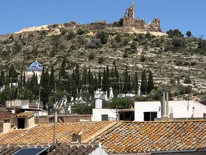 A hillside with ruins and a white building with a blue dome. - Casa María (Artana)