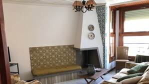 Una sala de estar con un sofá estampado, una mesa de madera y una chimenea.