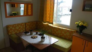 Stacaravan, meerdere bedden (CAPRAIA) | Woonruimte | Een flatscreentelevisie