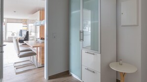A modern kitchen with a dining area, a glass cabinet, and a small table.
