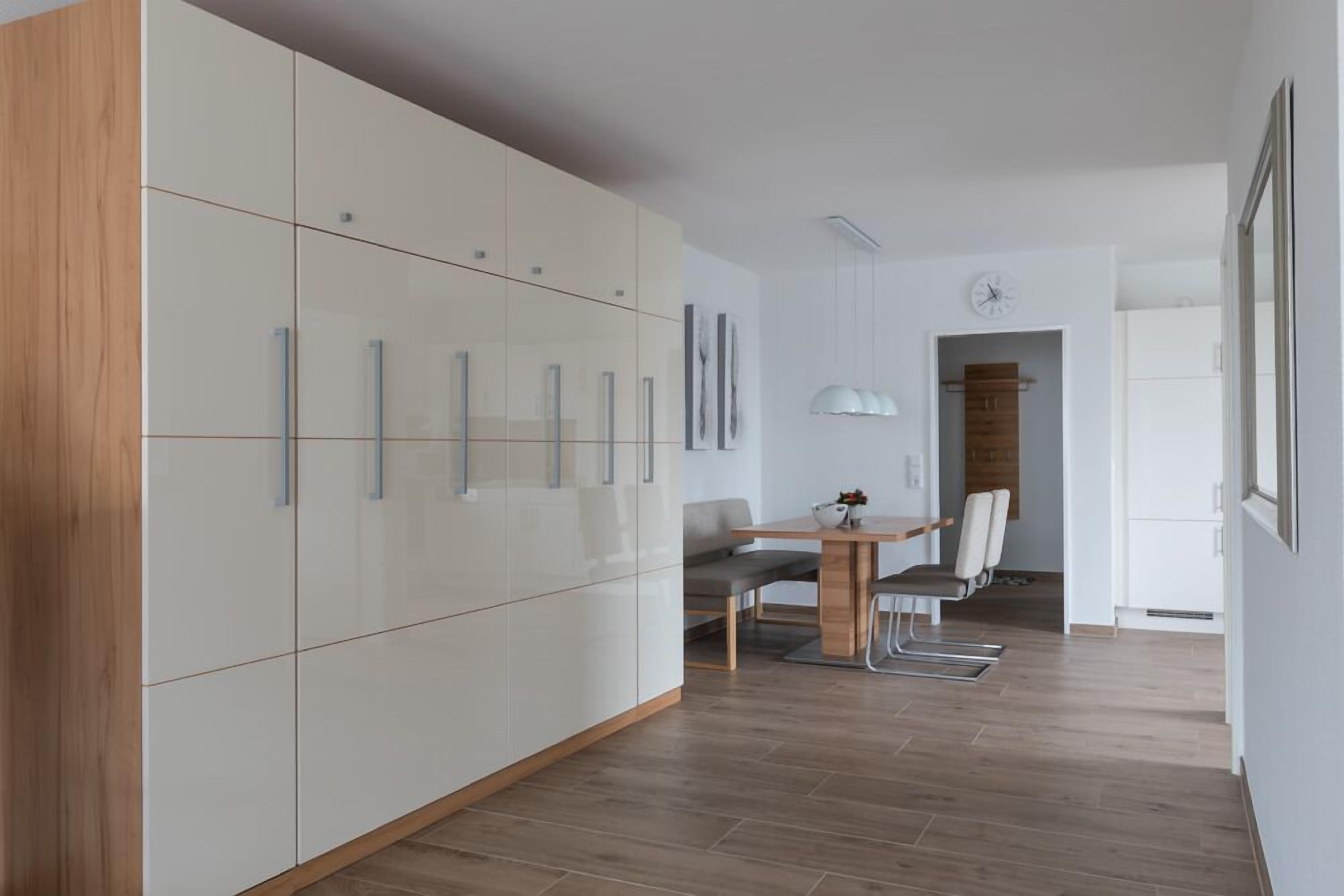 Una cocina moderna con armarios blancos y una pared decorativa de madera.