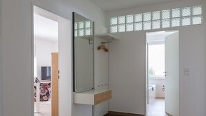 Une salle de bain moderne avec un grand miroir, un meuble-lavabo en bois et un espace douche.