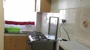 Une cuisine équipée d’une cuisinière à gaz, d’un four à micro-ondes et de placards.