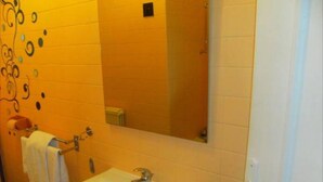 A bathroom with a white sink, a mirror, and a towel rack. - Le Petit Blanzou (Pierre-Buffiere)