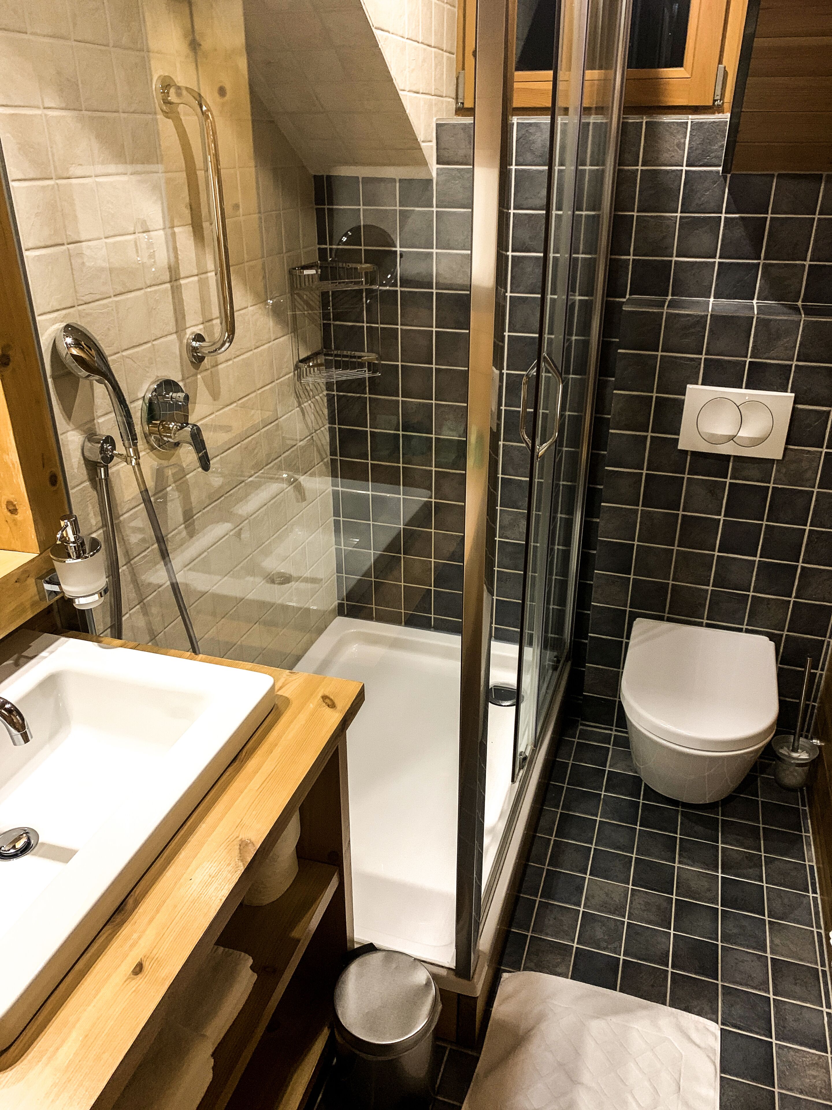 A bathroom with a glass-enclosed shower, a white bathtub, a sink, and a toilet.