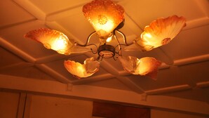 A ceiling with a decorative chandelier featuring multiple glass shades and a central light fixture. - Hotel Sathyam (Pudukkottai)