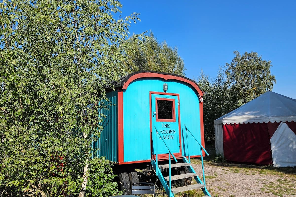 A turquoise and red vintage train car with a sign reading "The Faquirs Wagon."
