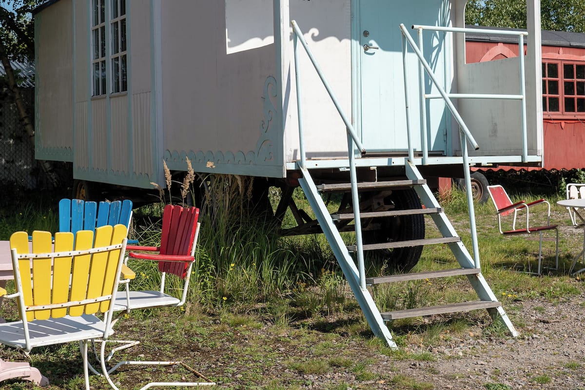 A small, white, single-story building with a curved roof, labeled "Balinas Wonderland." It features a set of stairs leading to a door, surrounded by colorful chairs and a small table.
