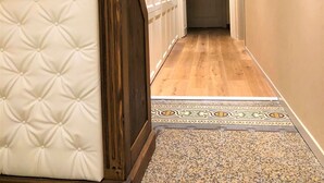 A hallway with a wooden bench, a patterned rug, and framed artwork on the walls. - Chalet Lucca (Lucca)