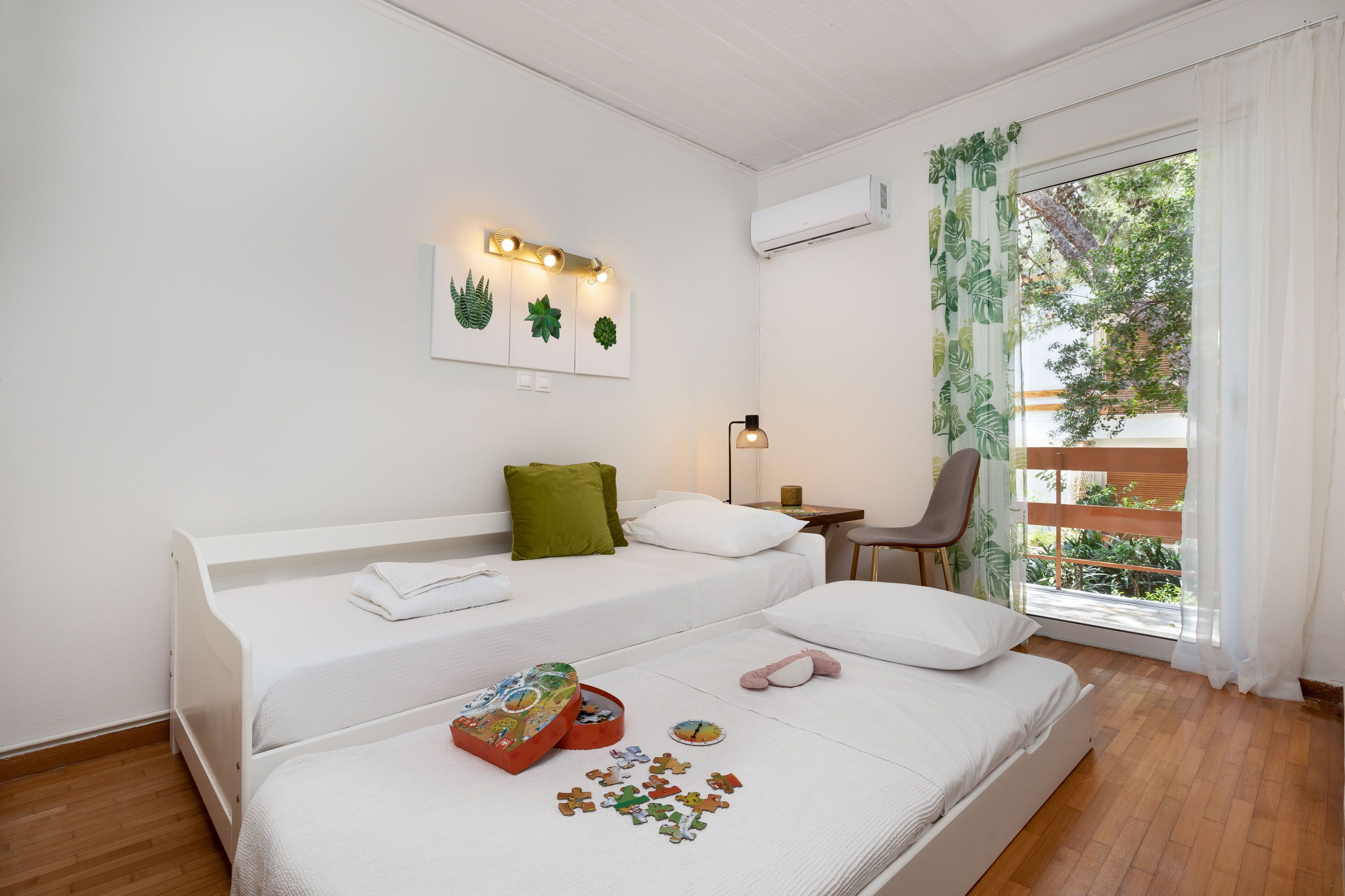 Un dormitorio con dos camas, un escritorio y una ventana con cortinas.