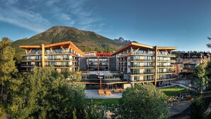 Un hotel moderno con varios pisos, amplias ventanas y un atrio central.