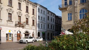 A street with historic buildings, a restaurant named 'GOSPODA', and parked cars. - Ermine Suites (Kraków)