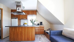 A modern kitchen with a central island, wooden cabinets, and a built-in stove.