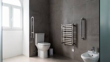 A modern bathroom with a toilet, bidet, and sink.