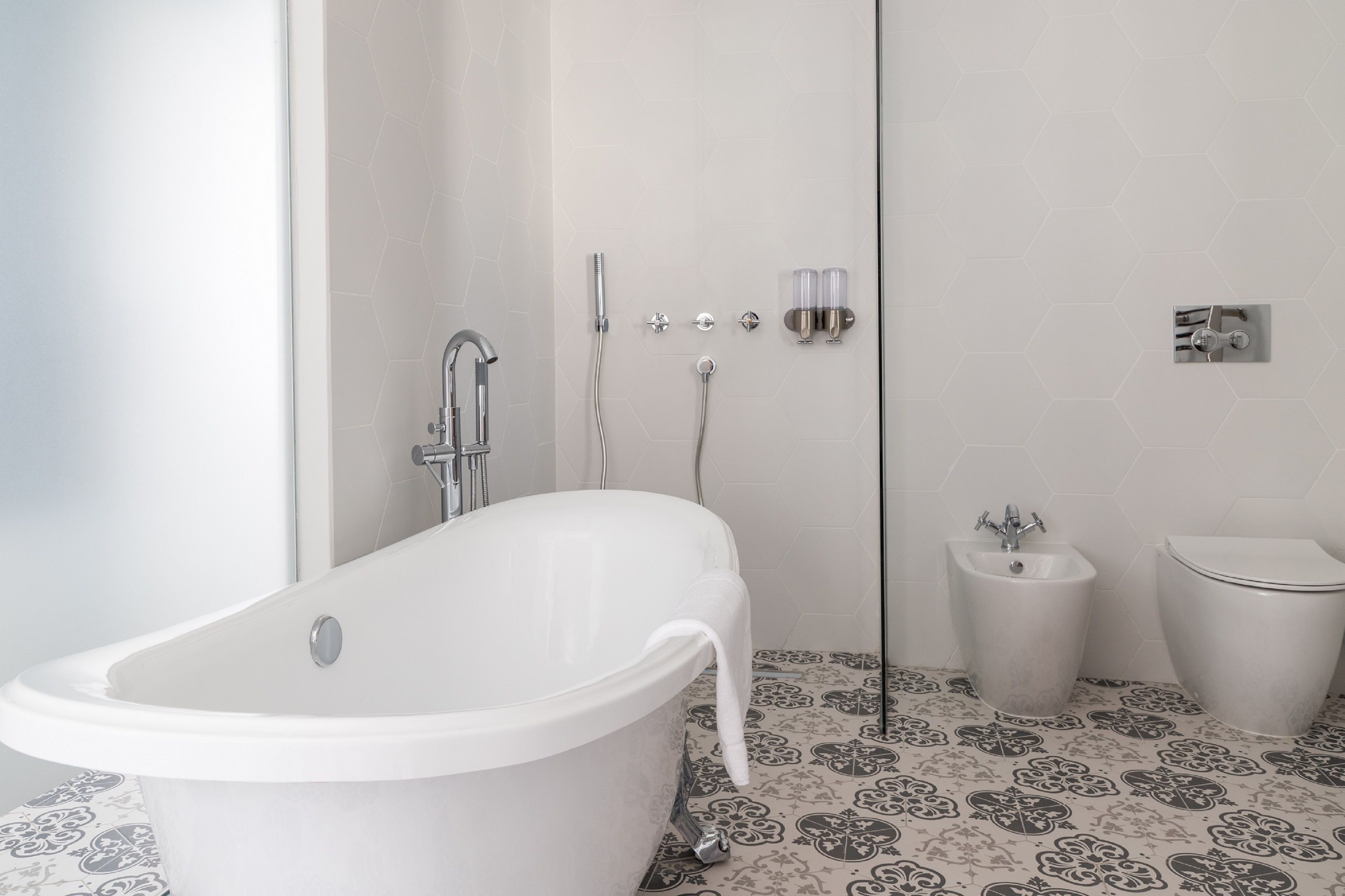 Une salle de bain comprenant une baignoire sur pieds, une douche, un bidet et des toilettes.