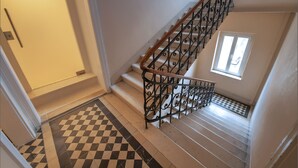 A staircase with a checkered floor and a window at the top.