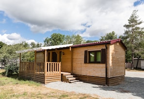 A small wooden cabin with a porch and steps leading to the entrance.