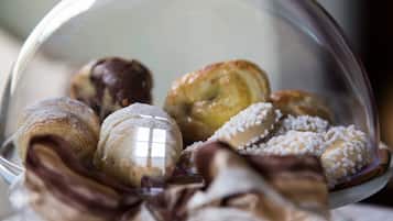 Diverse gebakjes gepresenteerd in een glazen bolvormige etui.