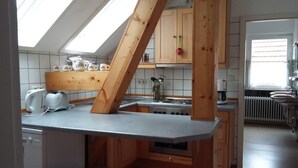 A kitchen with a skylight, wooden cabinets, a built-in oven, and a countertop.