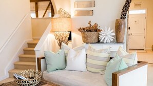 A living room with a sofa, cushions, a coffee table, a lamp, a basket, and a decorative vase. - Voted best bridal /wedding family stay in the city! Come experience the memories (Cincinnati)