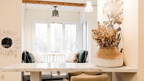 A dining area with a wooden table, chairs, and a vase of dried flowers. - Voted best bridal /wedding family stay in the city! Come experience the memories (Cincinnati)