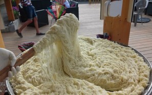 A large, white, fluffy substance being poured from a container into a tray. - Camping Bois de Gravière (Besse-et-Saint-Anastaise)