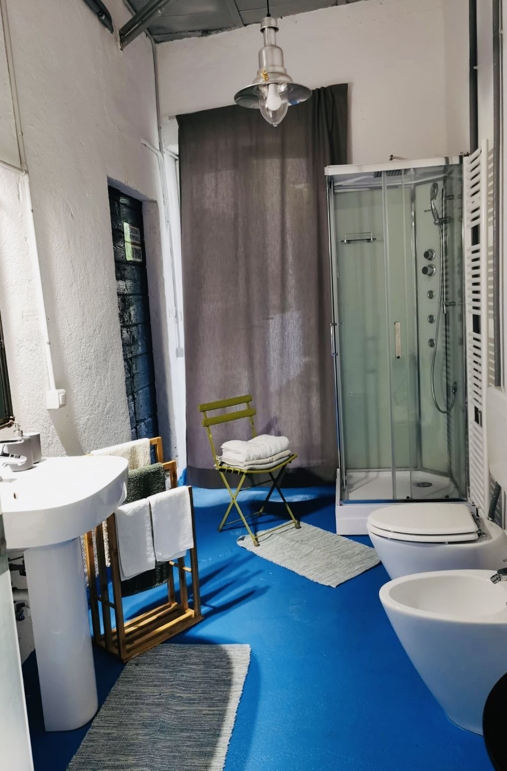 Een badkamer met douche, wastafel en toilet.