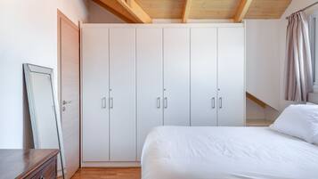 Una camera da letto con un letto grande, un armadio e un soffitto in legno.