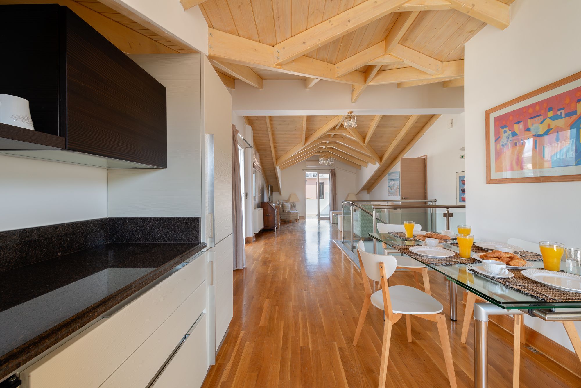 A modern kitchen with a black countertop and wooden beams on the ceiling.