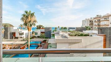 Una piscina al aire libre, sombrillas, sillones reclinables de piscina