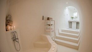 Une salle de bain moderne avec une baignoire sur pieds, une douche et un escalier menant à un petit coin cuisine.