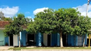 Une rangée de bâtiments bleus, avec des arbres devant.