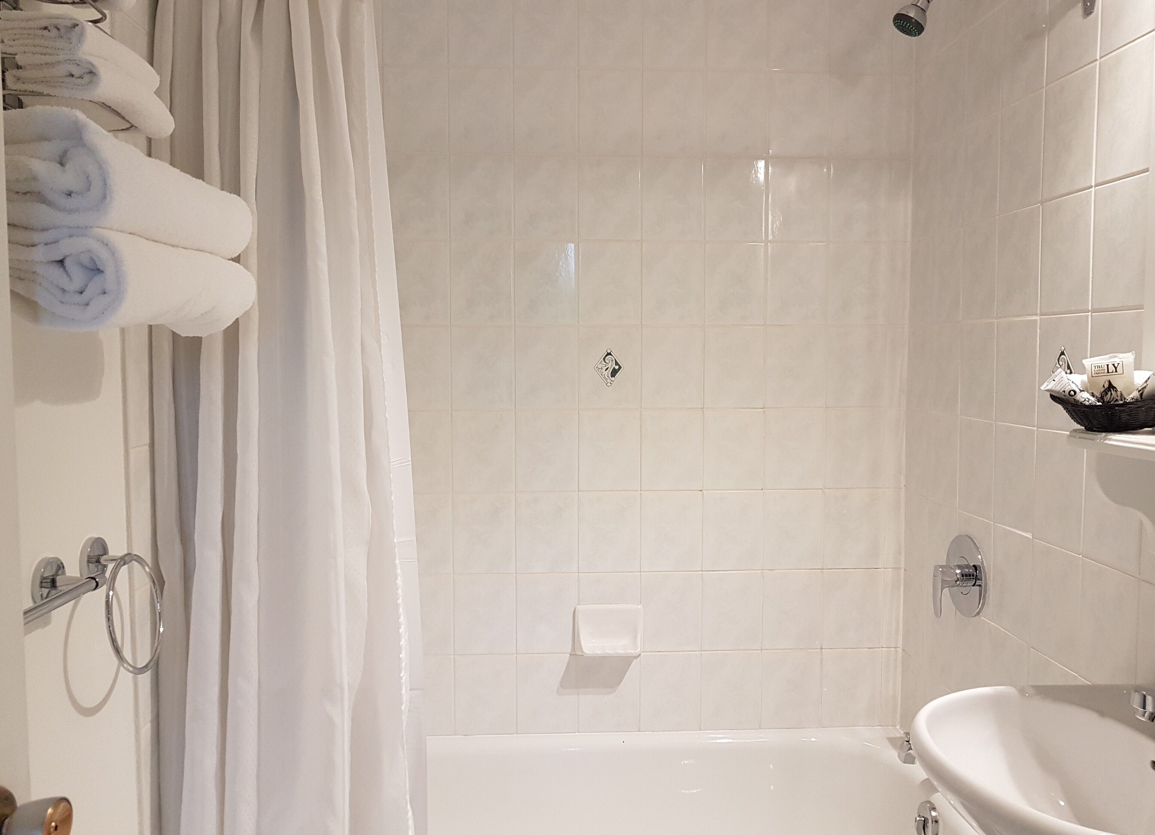 Een moderne badkamer met een bad, wastafel en douche.
