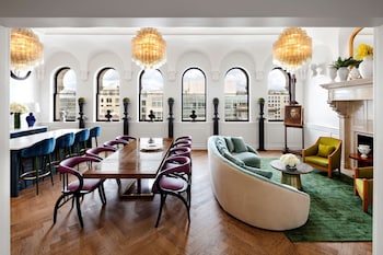A room with a red sofa, two round tables, and a red lamp. at Riggs Washington DC