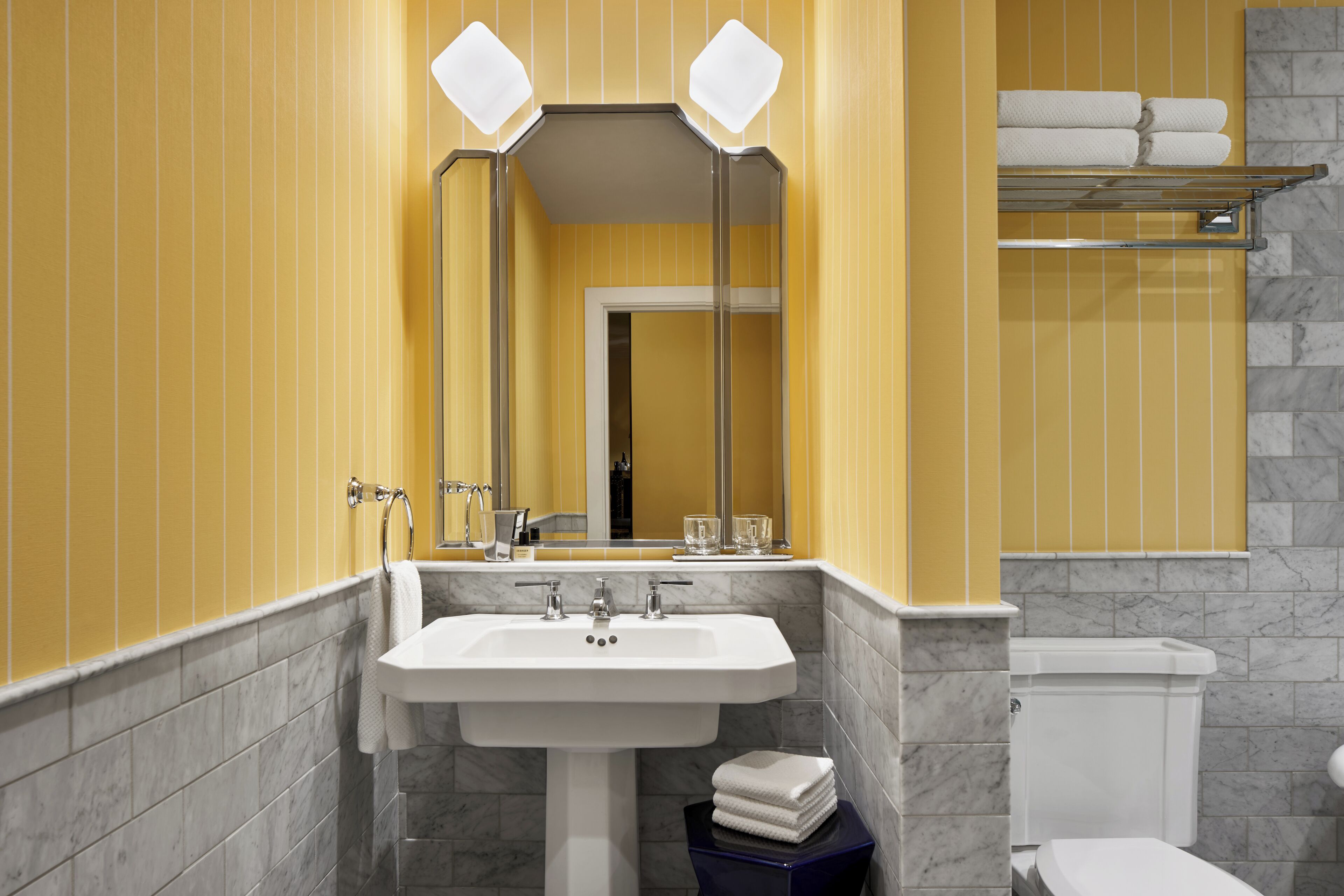 A bathroom with a white sink, a mirror, and a toilet.
