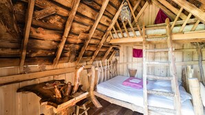 A rustic wooden cabin with a loft bed, a wooden desk, and a ladder. - Camping Les Castors - Cabanes Insolites (Burnhaupt-le-Haut)
