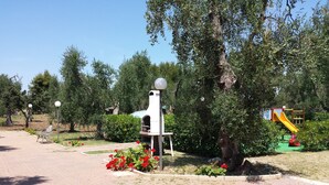 A park with a playground, benches, and a paved walkway. - Residence Alba (Vieste)