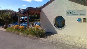 Un edificio pequeño con un letrero que dice "Camping La Croix Bateau" y una ventana circular.