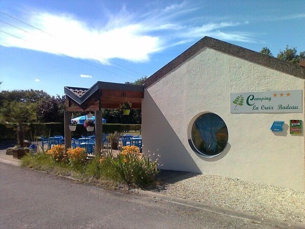 A small building with a sign reading "Camping La Croix Bateau" and a circular window. - Camping La Croix Badeau Tentes équipées (Soulaines-Dhuys)