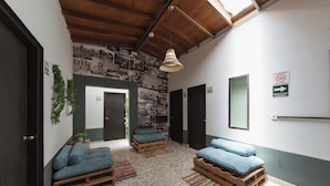 A modern room with two wooden beds, a large window, and a wall decorated with black and white photos. - Living Hostal - Hostel (Medellín)
